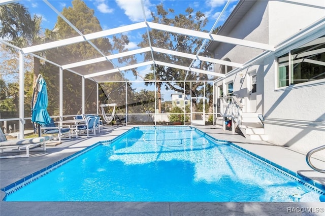 view of pool featuring glass enclosure and a patio