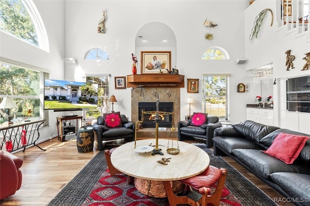 living room with plenty of natural light, a high ceiling, and light wood-type flooring