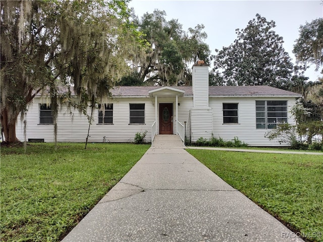 single story home featuring a front lawn