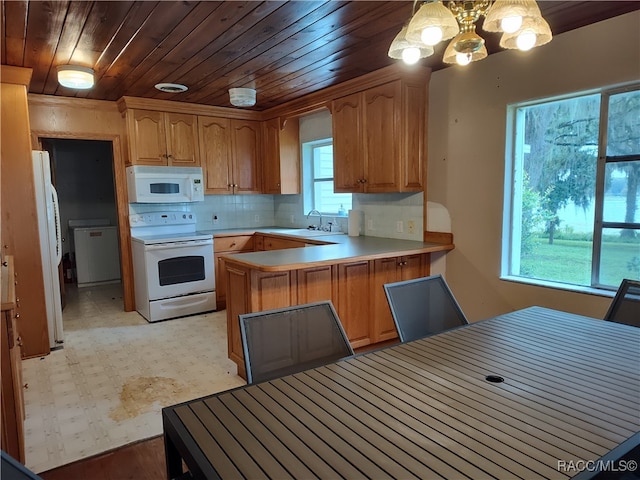 kitchen with pendant lighting, plenty of natural light, white appliances, and kitchen peninsula