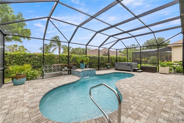 pool featuring a lanai, a patio, and a hot tub
