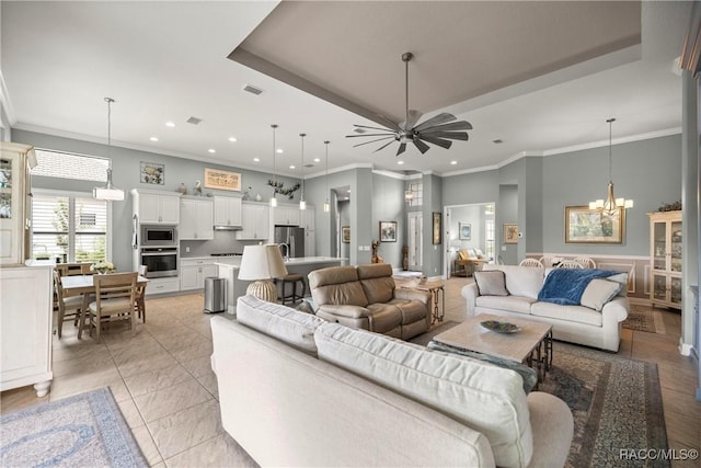living area with ornamental molding, visible vents, recessed lighting, and ceiling fan with notable chandelier