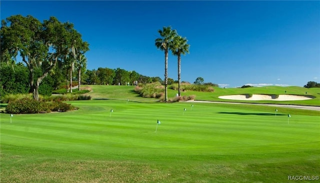 surrounding community featuring a yard and golf course view