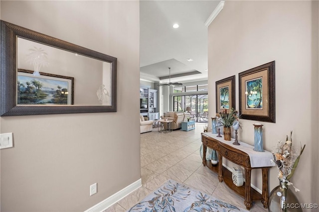 corridor with a raised ceiling, baseboards, and recessed lighting
