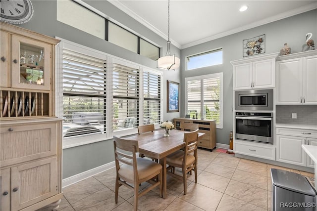 dining space featuring crown molding, recessed lighting, baseboards, and a towering ceiling