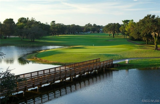 view of community featuring a water view, a yard, and view of golf course
