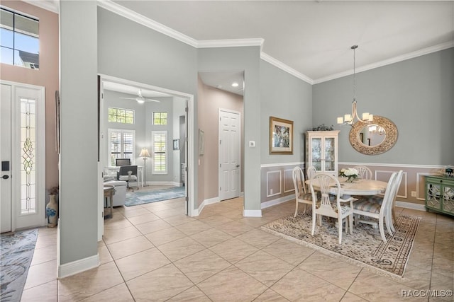 dining room with ornamental molding, a towering ceiling, and light tile patterned floors