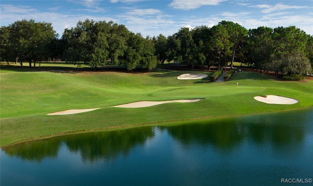 view of property's community featuring a lawn, view of golf course, and a water view