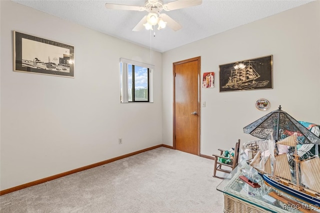 playroom with ceiling fan, carpet flooring, and a textured ceiling