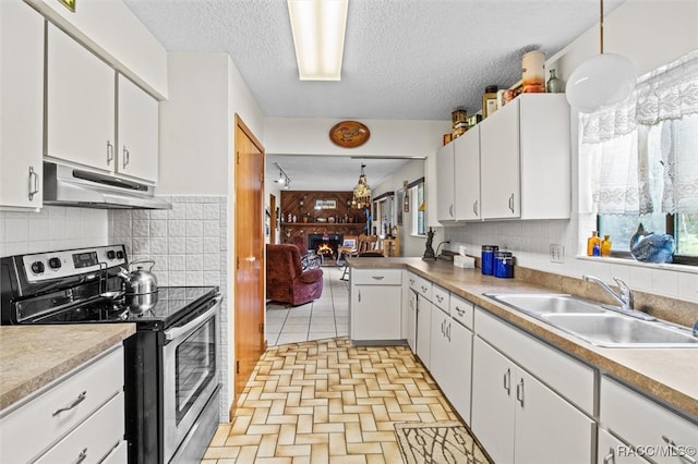 kitchen with decorative light fixtures, white cabinetry, and stainless steel electric range oven