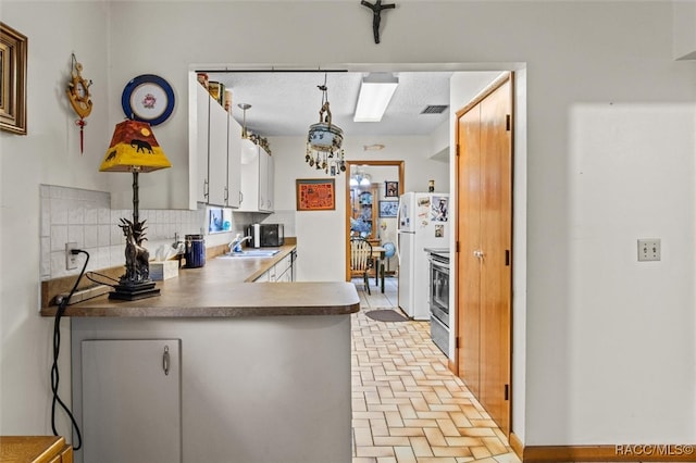 kitchen featuring stainless steel range with electric stovetop, sink, tasteful backsplash, decorative light fixtures, and white cabinetry