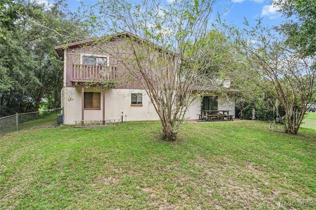 back of house featuring central AC and a lawn