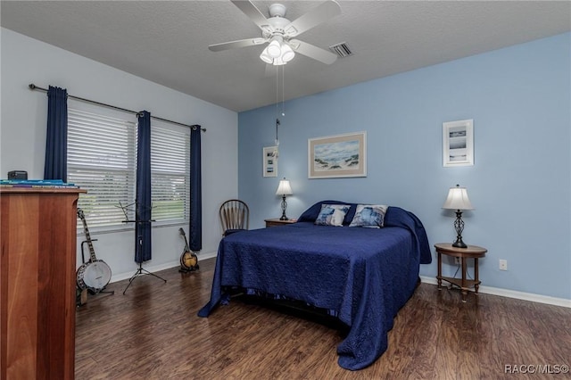 bedroom featuring a textured ceiling, ceiling fan, and dark hardwood / wood-style floors