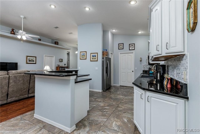 kitchen featuring white cabinetry, sink, ceiling fan, tasteful backsplash, and stainless steel fridge