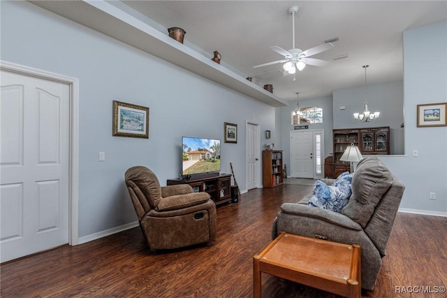 living room with dark hardwood / wood-style flooring and ceiling fan with notable chandelier