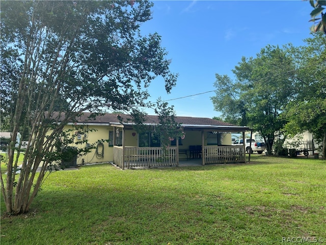 rear view of house featuring a lawn