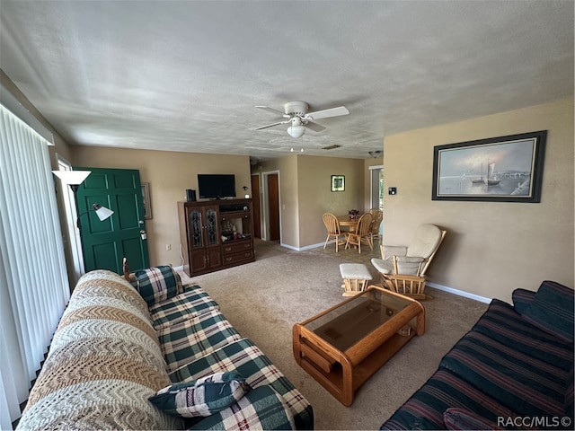 living room featuring carpet, a textured ceiling, and ceiling fan