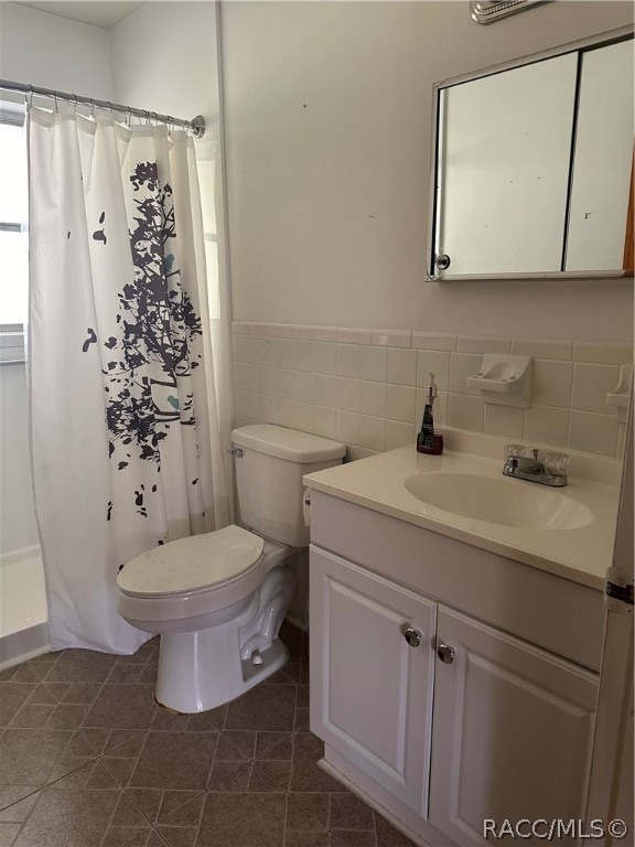 bathroom with tile patterned flooring, vanity, toilet, and a shower with shower curtain