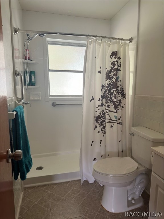 bathroom featuring tile patterned floors, curtained shower, vanity, and toilet