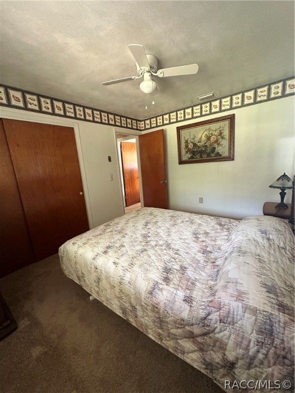 carpeted bedroom with ceiling fan and a textured ceiling