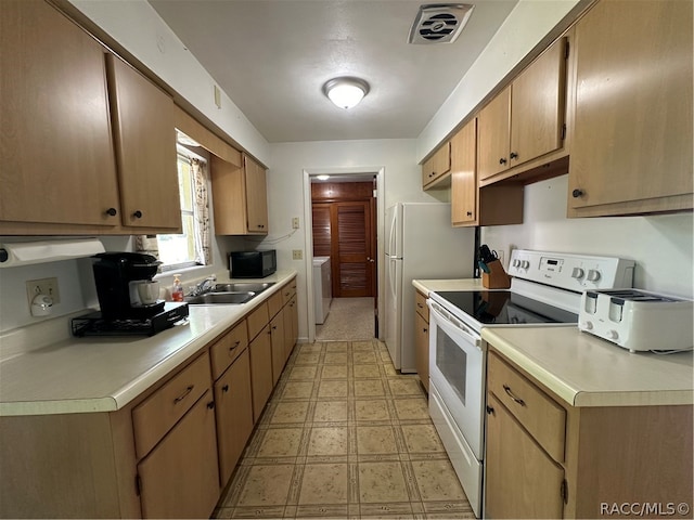 kitchen with white appliances, sink, and washer / clothes dryer