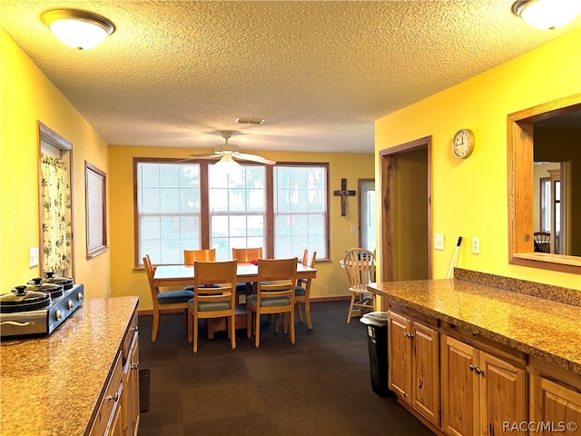 dining area with a textured ceiling and ceiling fan