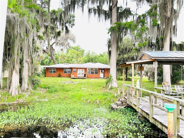 exterior space featuring a deck with water view and a yard