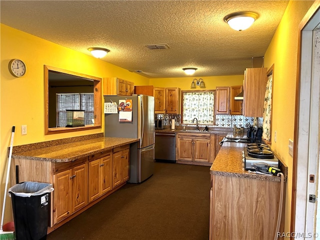 kitchen featuring a textured ceiling, stainless steel appliances, plenty of natural light, and sink