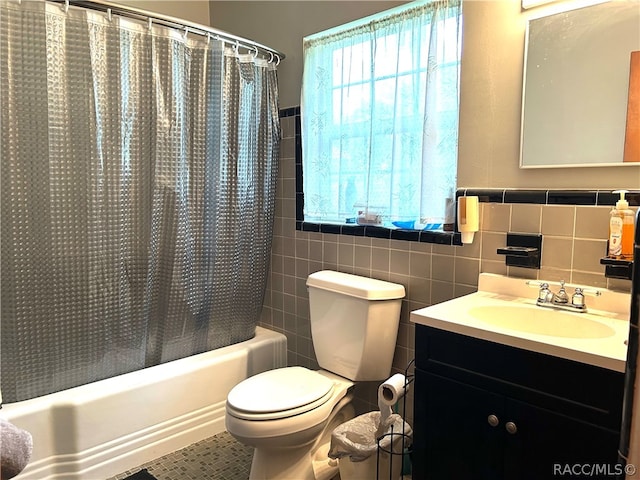 full bathroom with tile patterned flooring, toilet, and tile walls