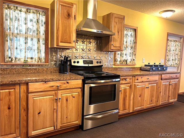 kitchen featuring stainless steel range with electric stovetop, dark carpet, backsplash, wall chimney range hood, and a textured ceiling