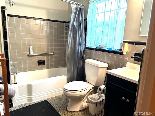 full bathroom featuring vanity, toilet, shower / bath combo with shower curtain, and tile walls