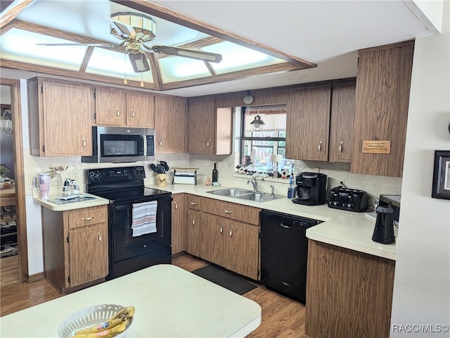 kitchen with decorative backsplash, ceiling fan, sink, black appliances, and light hardwood / wood-style floors