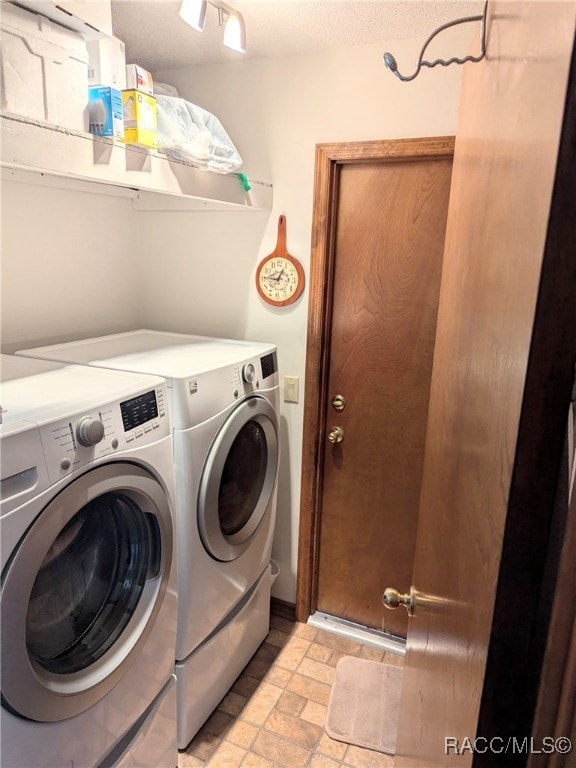 clothes washing area with washing machine and dryer