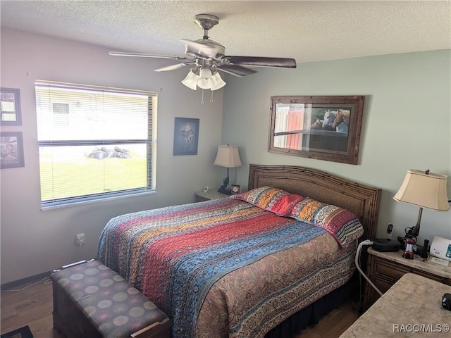 bedroom featuring a textured ceiling, ceiling fan, and dark wood-type flooring