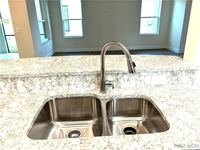 room details featuring light stone countertops and sink