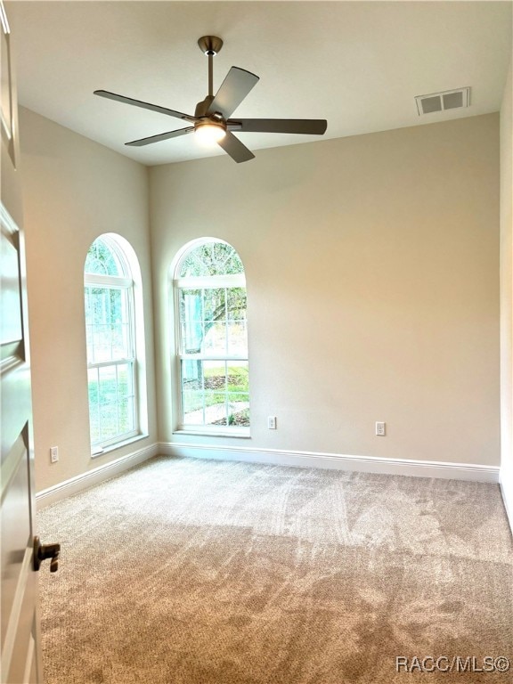 carpeted spare room featuring ceiling fan