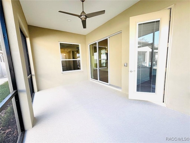 unfurnished sunroom with ceiling fan