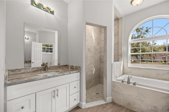 bathroom with vanity, hardwood / wood-style floors, and shower with separate bathtub