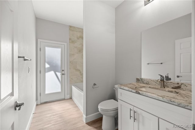 bathroom with hardwood / wood-style flooring, toilet, and vanity