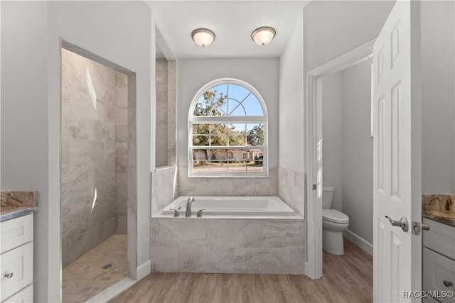 full bathroom featuring toilet, shower with separate bathtub, wood-type flooring, and vanity