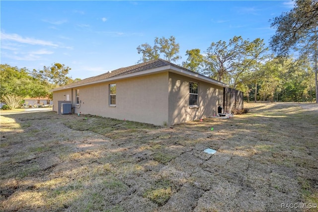 view of property exterior with cooling unit and a yard