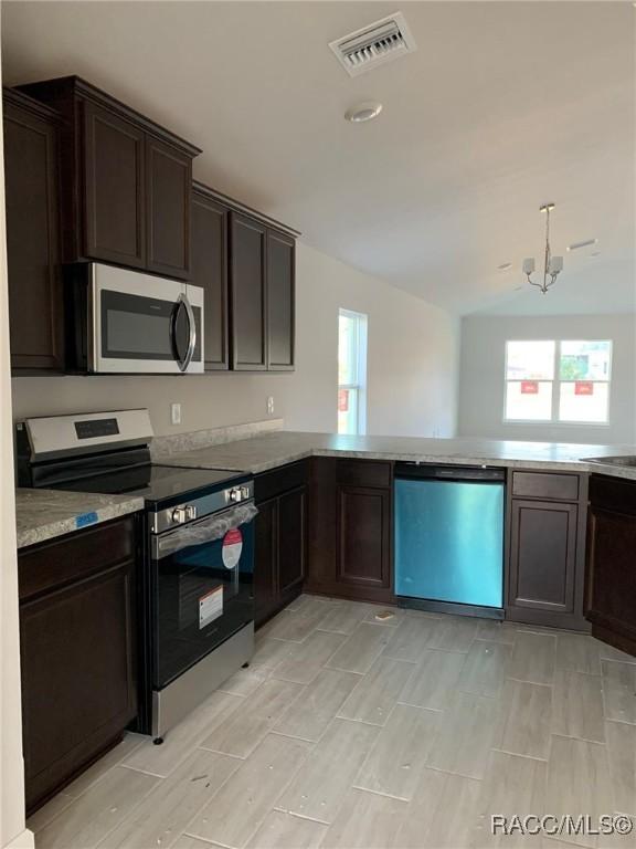 kitchen featuring a peninsula, visible vents, appliances with stainless steel finishes, and light countertops