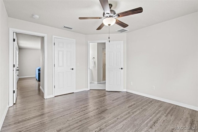 unfurnished bedroom featuring wood-type flooring and ceiling fan