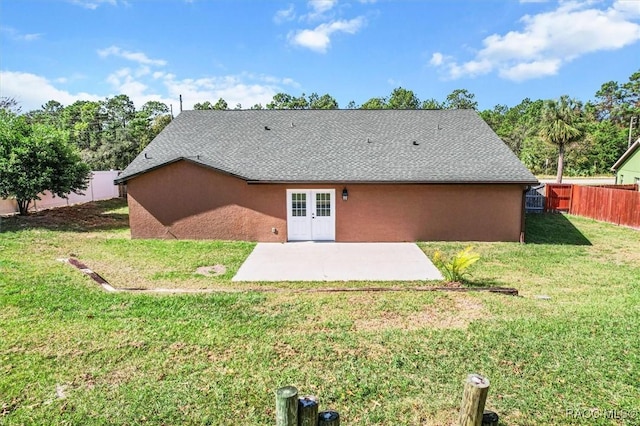 back of property with a lawn and a patio