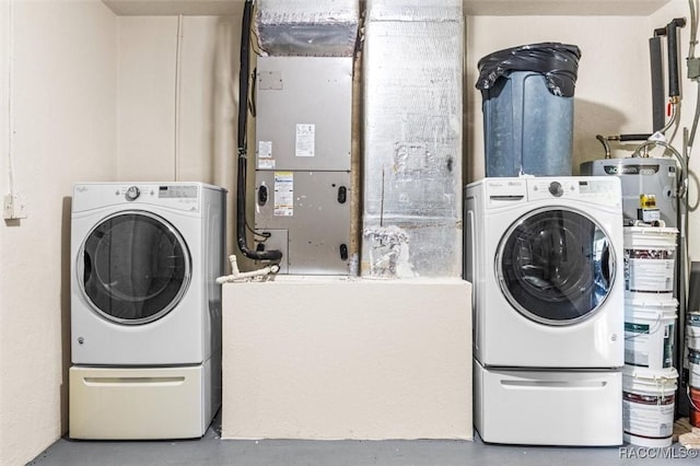 clothes washing area featuring washer and clothes dryer and water heater