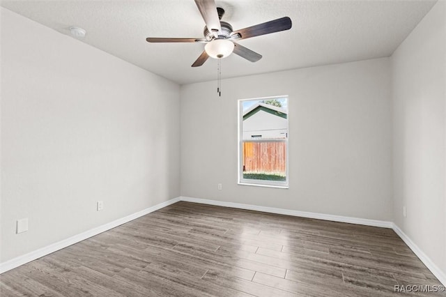 spare room featuring ceiling fan, dark hardwood / wood-style floors, and a textured ceiling