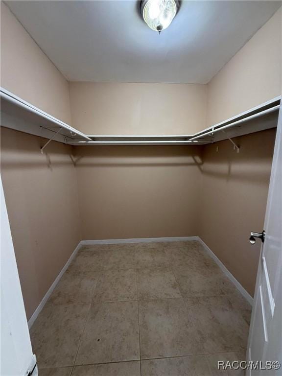 walk in closet featuring light tile patterned flooring