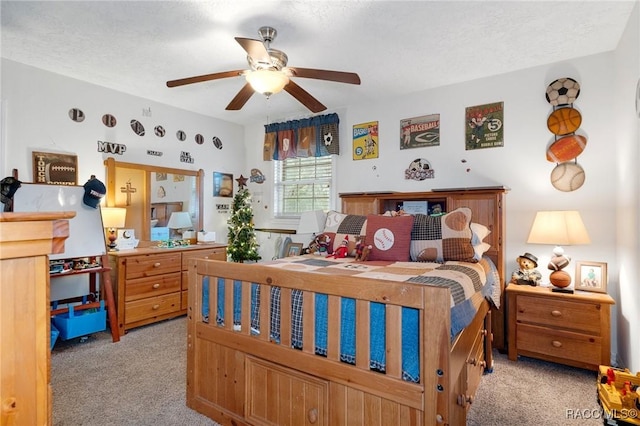 carpeted bedroom featuring ceiling fan and a textured ceiling