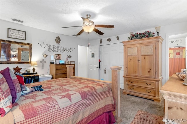 bedroom featuring a closet, ceiling fan, light colored carpet, and a textured ceiling