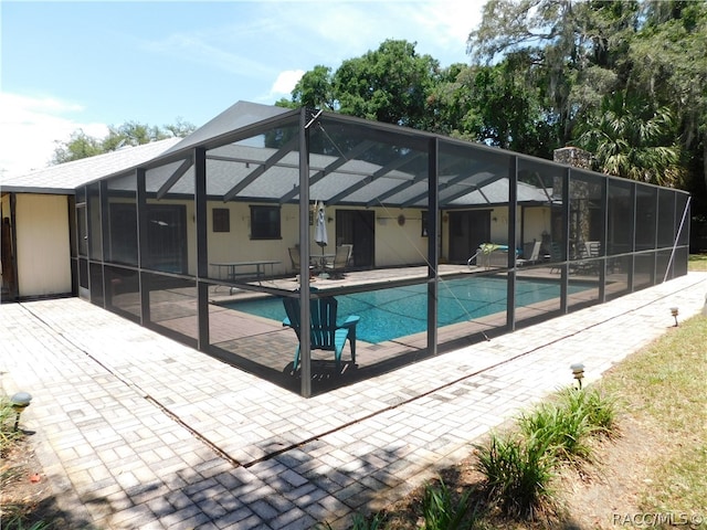 view of swimming pool with a lanai and a patio area